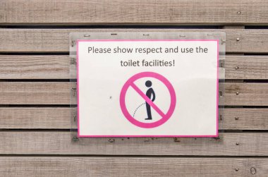 Reykjahlid, Iceland, April 27, 2022: sign on the wooden wall of a toilet facility kindly asking not to urinate in nature but instead use the toilet
