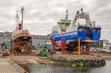 Stykkisholmur, İzlanda, 3 Mayıs 2022: Şehrin eski limanındaki bir tersanede onarılması gereken iki gemi