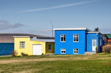 Hvammstangi, İzlanda, 1 Mayıs 2022: Parlak sarı ve maviye boyanmış iki mütevazı ev