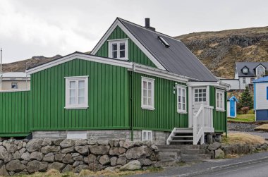 Flatey, İzlanda, 3 Mayıs 2022: Zemin katı, bodrum katı ve tavan arası, yeşil ahşap ön cepheli geleneksel ev