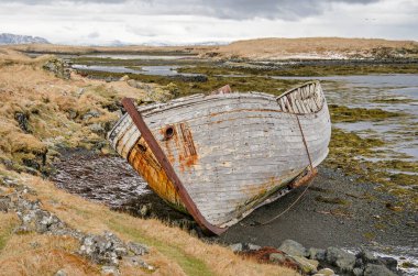 İzlanda 'da küçük bir sahilde eski ahşap bir teknenin enkazı.