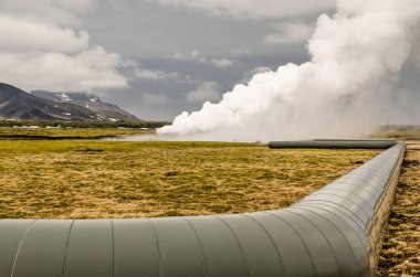 Hengill, İzlanda, 22 Nisan 2022: Hellisheidhi Jeotermal Santrali 'nin etrafındaki buhar bulutlarına doğru yosun tarlası üzerinden bakın.