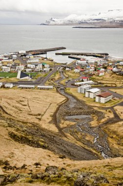 Olafsvik, İzlanda, 4 Mayıs 2022: Dağlardan ikona, liman, küçük nehir ve heykeltraş modern kilise manzarası