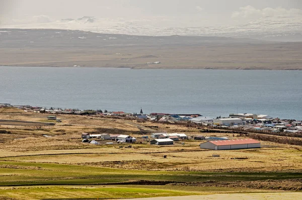 Hvammstangi, İzlanda, 1 Mayıs 2022: Dağlardan kasabaya doğru kilisesi, limanı, fiyordu ve ötesindeki topraklara bakın.
