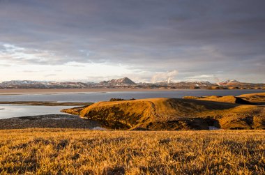 Skutustadhir, İzlanda, 27 Nisan 2022: Gün batımından önceki altın saat boyunca Myvatn Gölü kıyısındaki sahte kraterlerin su yüzeyine yakın görünüm