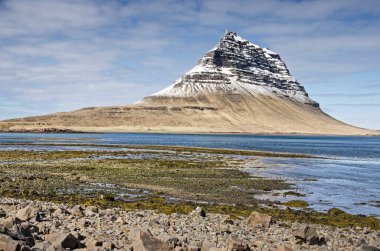 İzlanda 'da Grundarfjordhur yakınlarındaki ikonik Kirkjufell (Kilise Dağı)' na doğru uzanan bir dağ deresinin ağzına bakın.