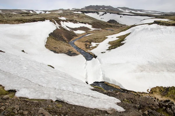 İzlanda 'nın Skogar yakınlarındaki dağlarda bir vadi boyunca manzarayı seyret, ilkbaharın başında yamaçlarında hala çok kar var.