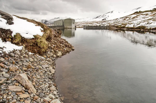 2022年5月4日アイスランドのオラフスヴィク ダムと水力発電所に向かって山の中の人工湖を渡って見る — ストック写真