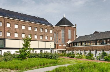 Rotterdam,  The Netherlands, June 18, 2022: the former Noordsingel prison building, redeveloped in a residential complex with communal garden