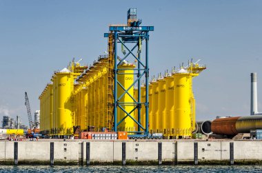 Rotterdam, The Netherlands, August 23, 2022: view from the habour to the quay with large foundation pieces for future wind turbines on Maasvlakte industrial area