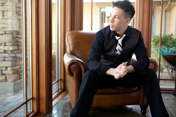 Model mężczyzna nosi oficjalne garnitur i krawat, siedząc w fotelu — Zdjęcie stockowe