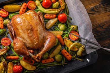 İki tavuk ve sebze için şölen yemeği. Fırında tavuk, fırında yeşil fasulye, bebek havuç, patates, yeşil biber ve Brüksel lahanası. İki kadeh şarap..
