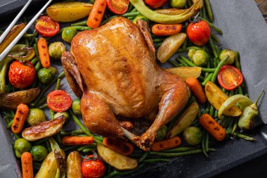 İki tavuk ve sebze için şölen yemeği. Fırında tavuk, fırında yeşil fasulye, bebek havuç, patates, yeşil biber ve Brüksel lahanası. İki kadeh şarap..