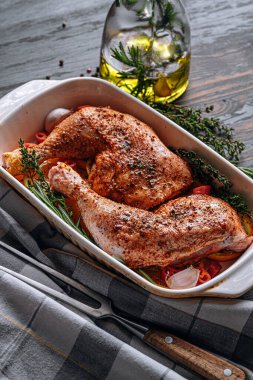 Çiğ hindi butları baharat ve tuzla ovulmuş, fırın tepsisine portakal limonlu sarımsaklı biberiye kekiği ve zeytinyağıyla birlikte. İki kişilik sağlıklı ve lezzetli bir akşam yemeği konsepti.