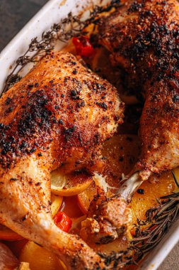 Kızarmış hindi budu, baharat ve tuzla ovulmuş, portakallar, limonlar, sarımsak, biberiye, kekik ve zeytinyağı ile pişirilmiş. İki kişilik sağlıklı ve lezzetli bir akşam yemeği konsepti.