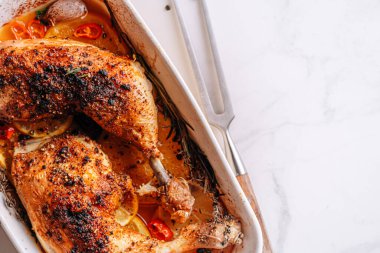 Kızarmış hindi budu, baharat ve tuzla ovulmuş, portakallar, limonlar, sarımsak, biberiye, kekik ve zeytinyağı ile pişirilmiş. İki kişilik sağlıklı ve lezzetli bir akşam yemeği konsepti.