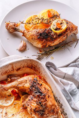 Kızarmış hindi budu, baharat ve tuzla ovulmuş, portakallar, limonlar, sarımsak, biberiye, kekik ve zeytinyağı ile pişirilmiş. İki kişilik sağlıklı ve lezzetli bir akşam yemeği konsepti.