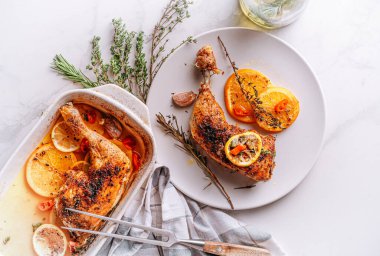 Kızarmış hindi budu, baharat ve tuzla ovulmuş, portakallar, limonlar, sarımsak, biberiye, kekik ve zeytinyağı ile pişirilmiş. İki kişilik sağlıklı ve lezzetli bir akşam yemeği konsepti.