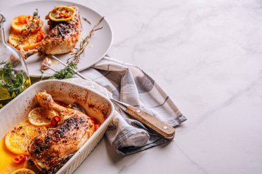 Kızarmış hindi budu, baharat ve tuzla ovulmuş, portakallar, limonlar, sarımsak, biberiye, kekik ve zeytinyağı ile pişirilmiş. İki kişilik sağlıklı ve lezzetli bir akşam yemeği konsepti.