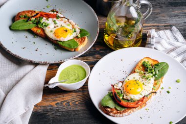 Lezzetli ve iştah açıcı bruschetta ve kahvaltıda kızarmış yumurta ve otlar.
