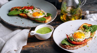Lezzetli ve iştah açıcı bruschetta ve kahvaltıda kızarmış yumurta ve otlar.