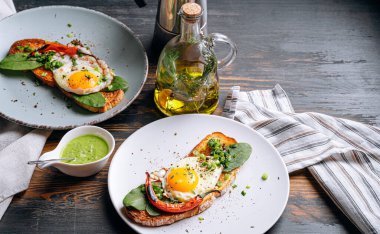 Lezzetli ve iştah açıcı bruschetta ve kahvaltıda kızarmış yumurta ve otlar.