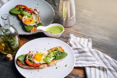 Lezzetli ve iştah açıcı bruschetta ve kahvaltıda kızarmış yumurta ve otlar.