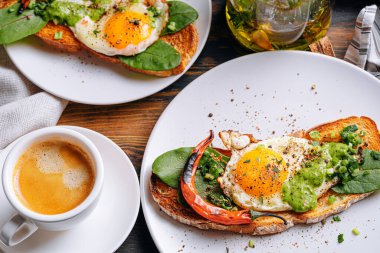 Sıcak ve yüksek kalorili kahvaltı. Lezzetli ve ağız sulandırıcı bruschetta ve kahvaltıda kızarmış yumurta ve bir fincan aromatik kahve..