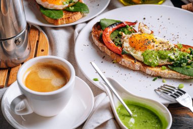 Sıcak ve yüksek kalorili kahvaltı. Lezzetli ve ağız sulandırıcı bruschetta ve kahvaltıda kızarmış yumurta ve bir fincan aromatik kahve..