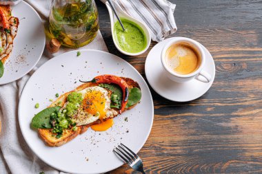 Sıcak ve yüksek kalorili kahvaltı. Lezzetli ve ağız sulandırıcı bruschetta ve kahvaltıda kızarmış yumurta ve bir fincan aromatik kahve..