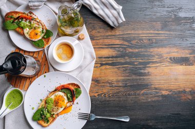 Sıcak ve yüksek kalorili kahvaltı. Lezzetli ve ağız sulandırıcı bruschetta ve kahvaltıda kızarmış yumurta ve bir fincan aromatik kahve..