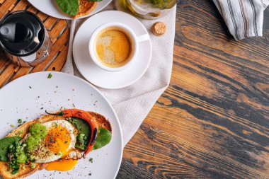 Sıcak ve yüksek kalorili kahvaltı. Lezzetli ve ağız sulandırıcı bruschetta ve kahvaltıda kızarmış yumurta ve bir fincan aromatik kahve..