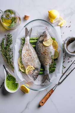 Dorado 'dan iki kişilik lezzetli bir akşam yemeği konsepti. Çiğ Dorado balığı, kuşkonmaz ve baharatlı limon.