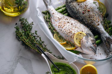 Dorado 'dan iki kişilik lezzetli bir akşam yemeği konsepti. Çiğ Dorado balığı, kuşkonmaz ve baharatlı limon.