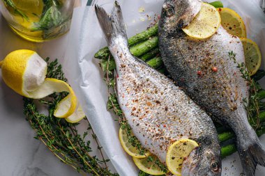 Dorado 'dan iki kişilik lezzetli bir akşam yemeği konsepti. Çiğ Dorado balığı, kuşkonmaz ve baharatlı limon.