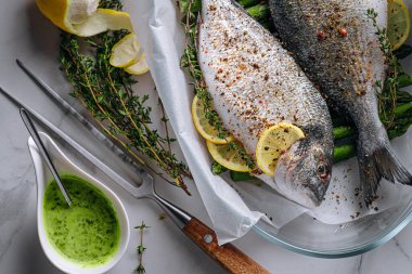 Dorado 'dan iki kişilik lezzetli bir akşam yemeği konsepti. Çiğ Dorado balığı, kuşkonmaz ve baharatlı limon.