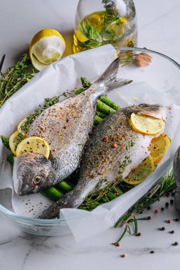 Dorado 'dan iki kişilik lezzetli bir akşam yemeği konsepti. Çiğ Dorado balığı, kuşkonmaz ve baharatlı limon.