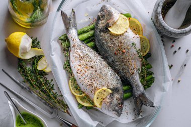 Dorado 'dan iki kişilik lezzetli bir akşam yemeği konsepti. Çiğ Dorado balığı, kuşkonmaz ve baharatlı limon.
