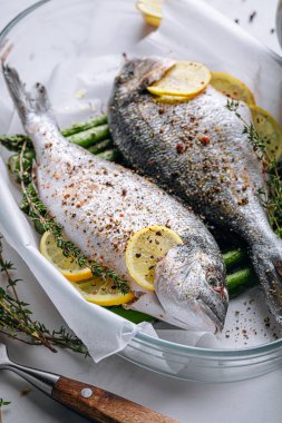 Dorado 'dan iki kişilik lezzetli bir akşam yemeği konsepti. Çiğ Dorado balığı, kuşkonmaz ve baharatlı limon.