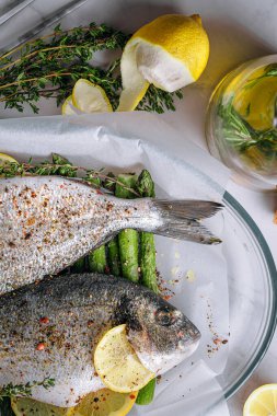 Dorado 'dan iki kişilik lezzetli bir akşam yemeği konsepti. Çiğ Dorado balığı, kuşkonmaz ve baharatlı limon.