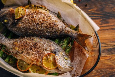 Dorado 'dan iki kişilik lezzetli bir akşam yemeği konsepti. Kuşkonmaz ve baharatlı limonlu fırında dorado balığı.