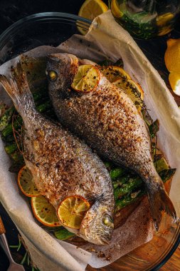 Dorado 'dan iki kişilik lezzetli bir akşam yemeği konsepti. Kuşkonmaz ve baharatlı limonlu fırında dorado balığı.