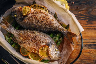 Dorado 'dan iki kişilik lezzetli bir akşam yemeği konsepti. Kuşkonmaz ve baharatlı limonlu fırında dorado balığı.