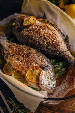 Dorado 'dan iki kişilik lezzetli bir akşam yemeği konsepti. Kuşkonmaz ve baharatlı limonlu fırında dorado balığı.