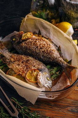 Dorado 'dan iki kişilik lezzetli bir akşam yemeği konsepti. Kuşkonmaz ve baharatlı limonlu fırında dorado balığı.