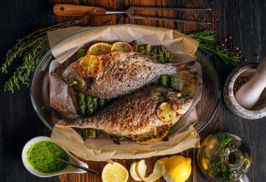 Dorado 'dan iki kişilik lezzetli bir akşam yemeği konsepti. Kuşkonmaz ve baharatlı limonlu fırında dorado balığı.