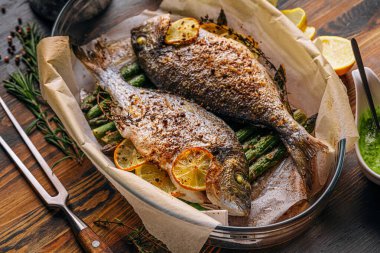 Dorado 'dan iki kişilik lezzetli bir akşam yemeği konsepti. Kuşkonmaz ve baharatlı limonlu fırında dorado balığı.