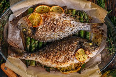 Dorado 'dan iki kişilik lezzetli bir akşam yemeği konsepti. Kuşkonmaz ve baharatlı limonlu fırında dorado balığı.