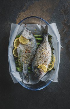 Limonlu ve kuşkonmazlı iki dorado balığı. İki kişilik lezzetli ve sağlıklı bir akşam yemeği konsepti.