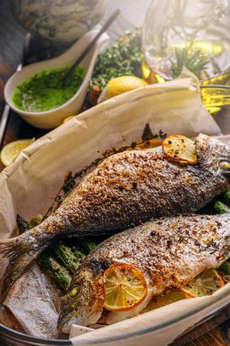 Dorado 'dan iki kişilik lezzetli bir akşam yemeği konsepti. Kuşkonmaz ve baharatlı limonlu fırında dorado balığı.